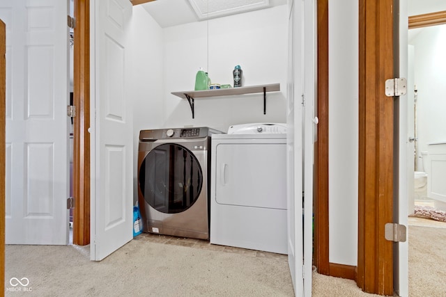 washroom featuring light carpet, laundry area, and washer and clothes dryer