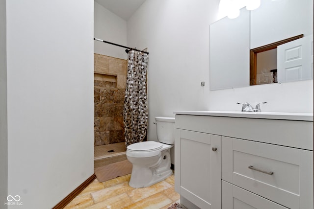 bathroom featuring tiled shower, vanity, and toilet