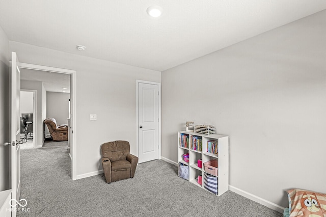 living area featuring carpet floors and baseboards