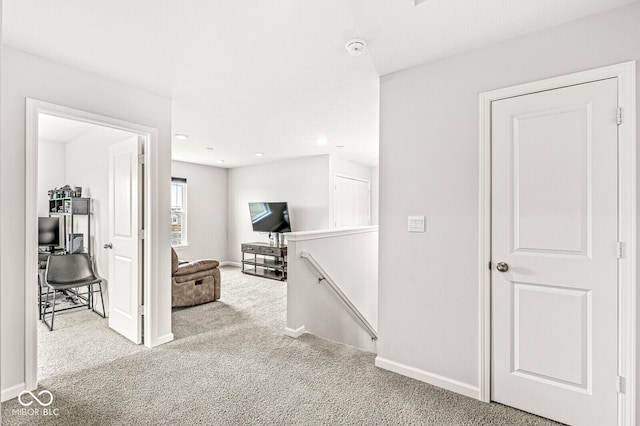 corridor with baseboards, carpet flooring, and an upstairs landing