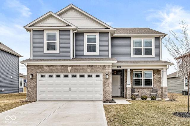 craftsman-style home featuring driveway, brick siding, a front lawn, and an attached garage