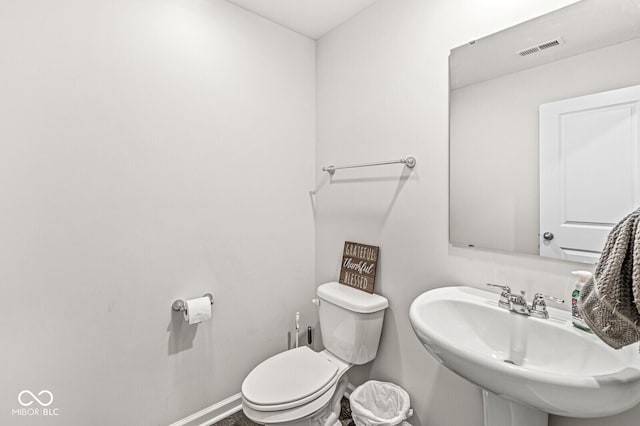 bathroom with visible vents, a sink, toilet, and baseboards