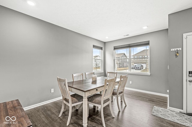 dining area with recessed lighting, a textured ceiling, baseboards, and wood finished floors