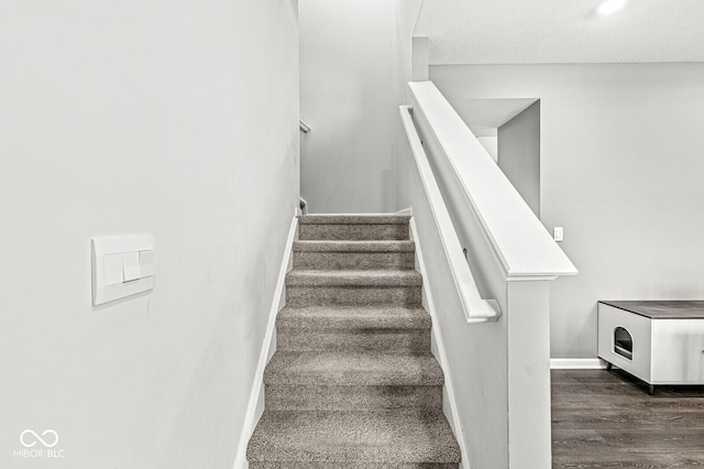 stairs with wood finished floors and baseboards