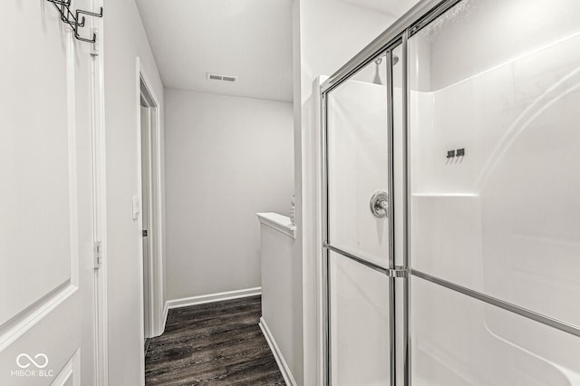 bathroom featuring baseboards, a shower stall, visible vents, and wood finished floors