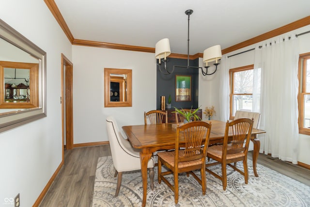 dining area with ornamental molding, light wood-style flooring, and baseboards