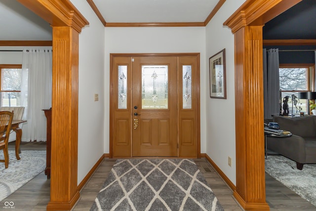 entryway with a healthy amount of sunlight, crown molding, ornate columns, and wood finished floors