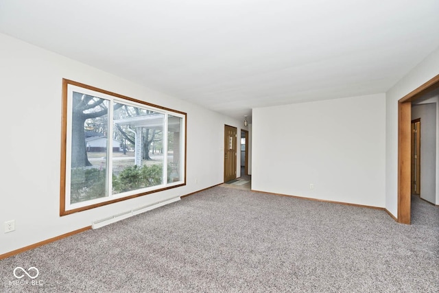 carpeted spare room with a baseboard radiator and baseboards