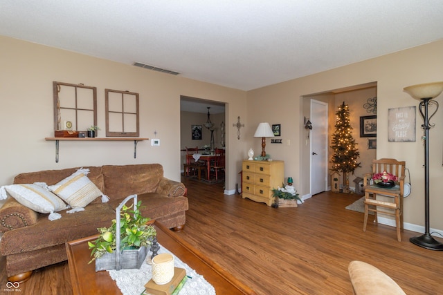 living area with visible vents, baseboards, and wood finished floors