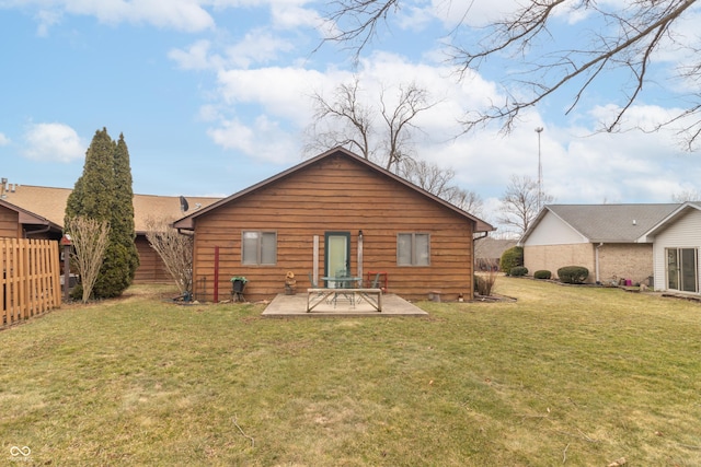 rear view of house with a lawn, a patio, and fence