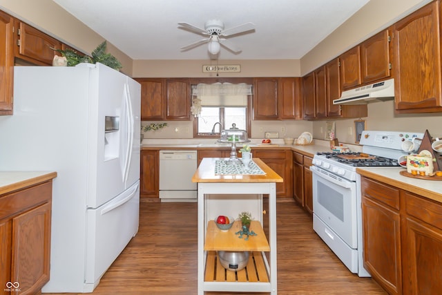 kitchen featuring white appliances, a ceiling fan, a sink, light countertops, and under cabinet range hood