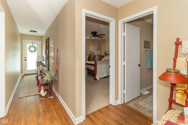 hallway with wood finished floors and baseboards