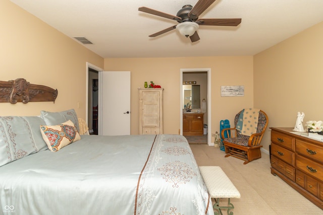 bedroom featuring a ceiling fan, ensuite bath, light colored carpet, and visible vents