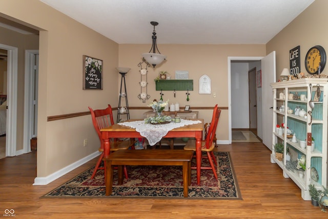 dining room with baseboards and wood finished floors