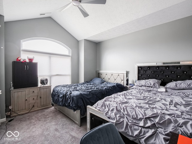 carpeted bedroom with lofted ceiling, visible vents, a ceiling fan, and a textured ceiling