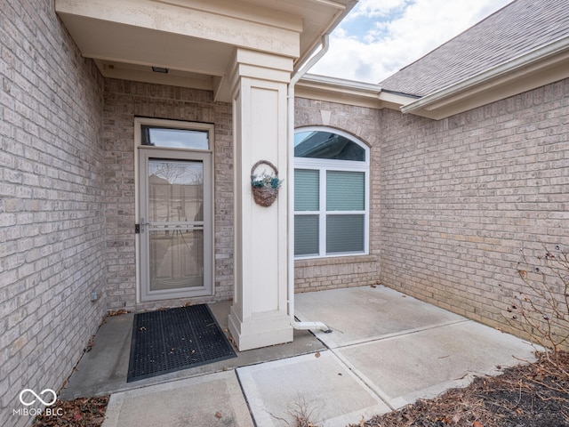 entrance to property featuring brick siding