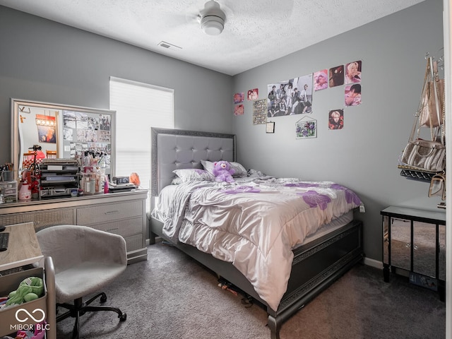 bedroom with visible vents, dark carpet, and a textured ceiling