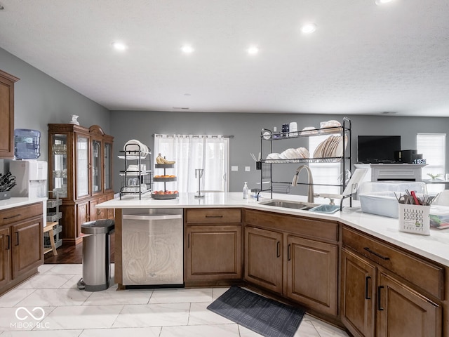 kitchen with dishwasher, light countertops, a sink, and recessed lighting