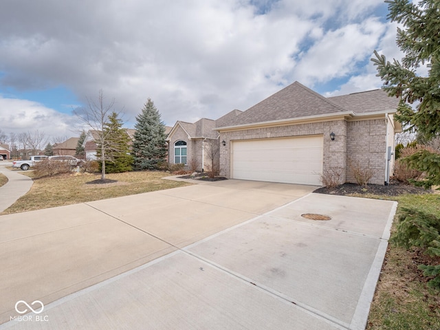 view of front facade with an attached garage, a shingled roof, concrete driveway, and brick siding