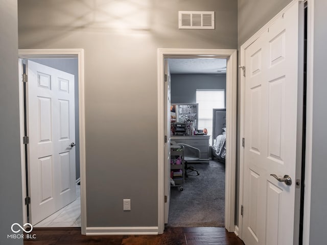 hall featuring visible vents and baseboards