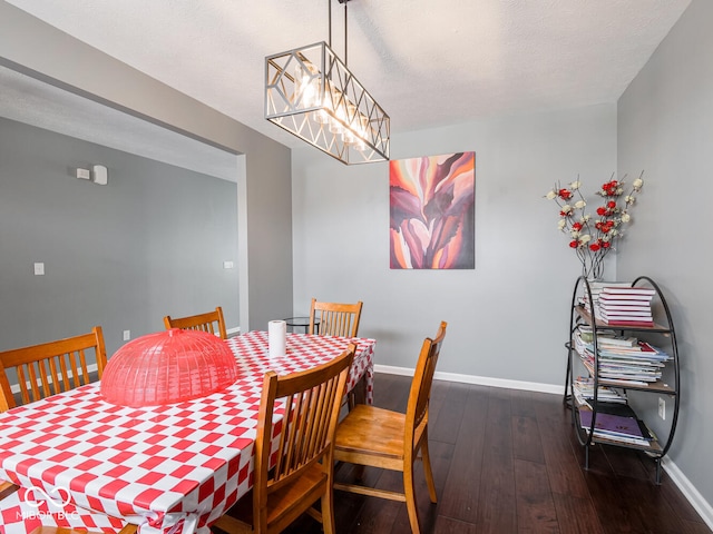 dining area featuring a notable chandelier, baseboards, and hardwood / wood-style flooring