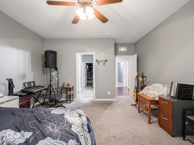 bedroom featuring a ceiling fan, light carpet, and baseboards