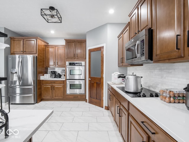 kitchen with stainless steel appliances, light countertops, and decorative backsplash