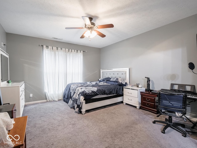 carpeted bedroom with a textured ceiling, ceiling fan, and visible vents