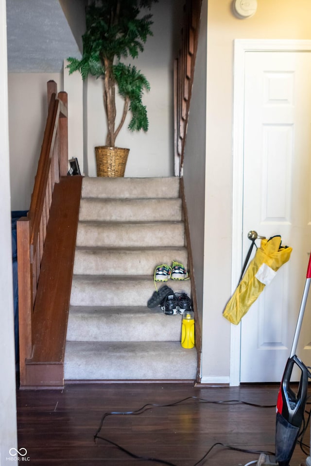 stairs featuring wood finished floors and baseboards