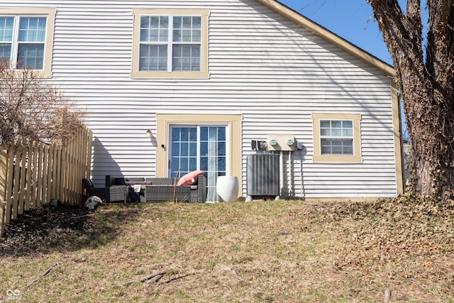 rear view of property with a lawn and fence