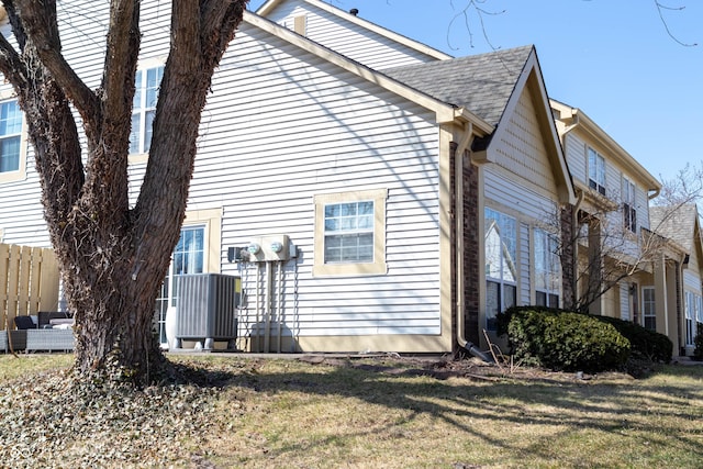 view of home's exterior featuring a lawn and a shingled roof