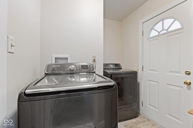 laundry room featuring laundry area, independent washer and dryer, and light wood-style flooring