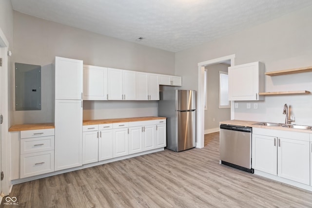 569 N Tacoma Ave, Indianapolis, IN 46201 - kitchen featuring electric panel, butcher block countertops, a sink, appliances with stainless steel finishes, and white cabinetry