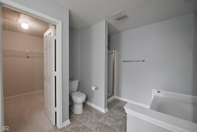 bathroom with a walk in closet, toilet, a shower stall, a textured ceiling, and baseboards