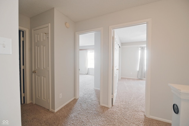 corridor with carpet floors and baseboards