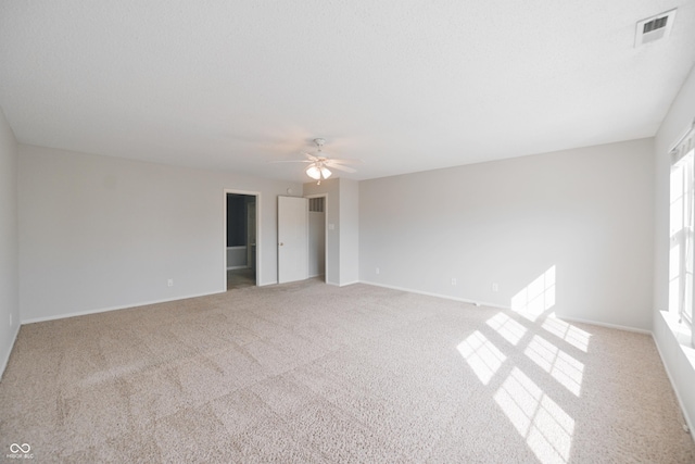 interior space featuring light carpet, visible vents, baseboards, ceiling fan, and a spacious closet