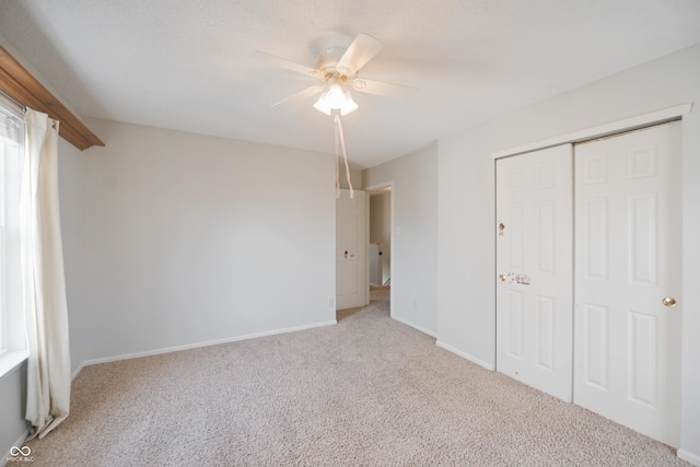 unfurnished bedroom with carpet, a closet, ceiling fan, and baseboards