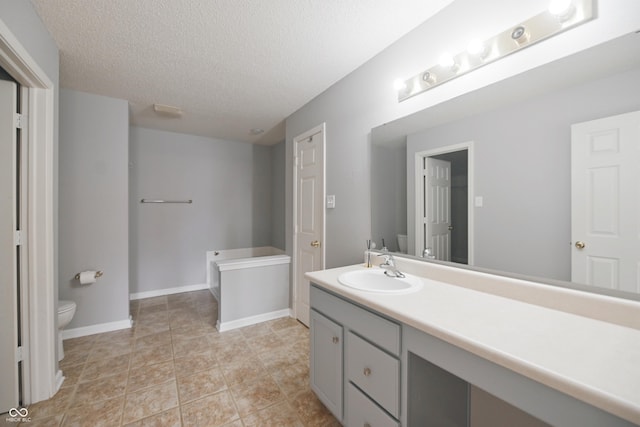 full bathroom with baseboards, toilet, a textured ceiling, vanity, and a bath