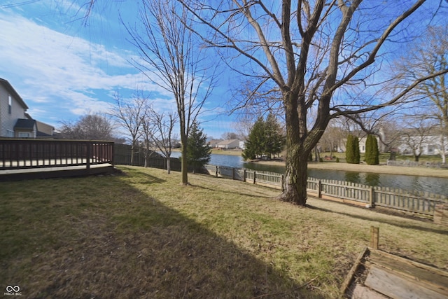 view of yard with fence private yard and a deck with water view