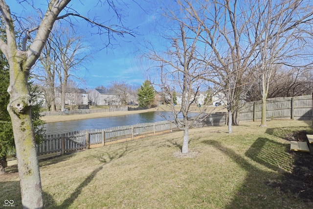 view of yard with a water view, a fenced backyard, and a residential view