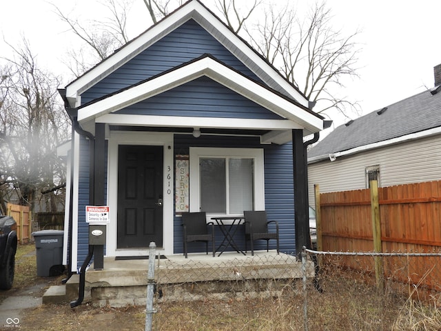 shotgun-style home with fence and a porch