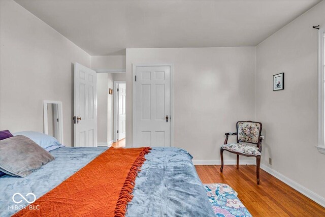 bedroom with baseboards and wood finished floors