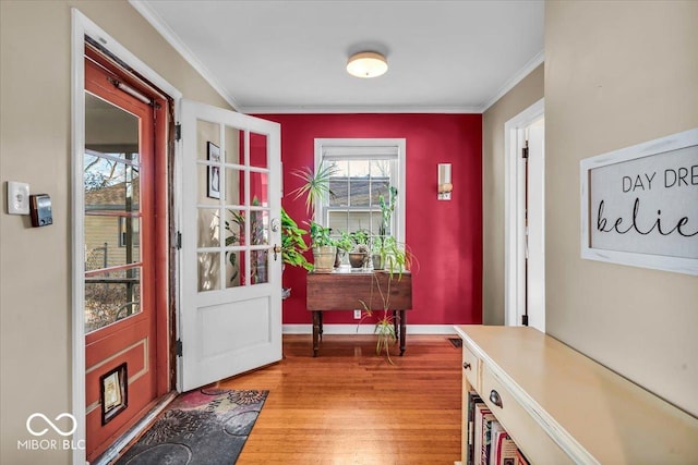 entryway featuring light wood-type flooring, baseboards, and ornamental molding