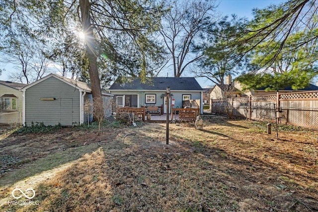 back of property with fence and a wooden deck