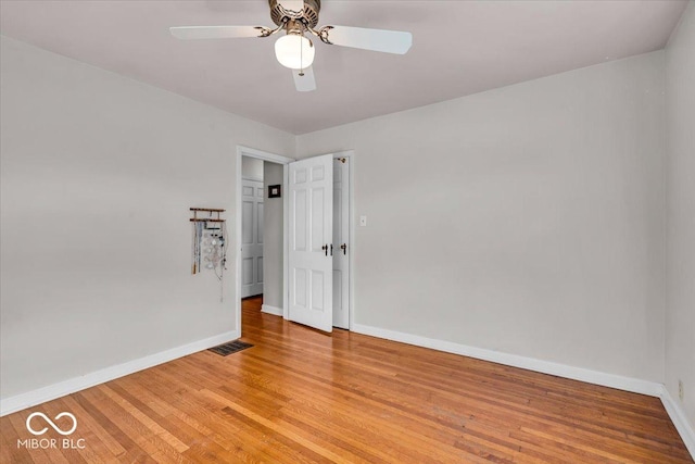 unfurnished room featuring a ceiling fan, baseboards, visible vents, and light wood finished floors