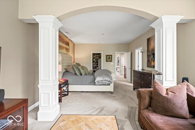 681 Greenford Trl N, Carmel, IN 46032 - bedroom featuring decorative columns, carpet flooring, arched walkways, and a walk in closet