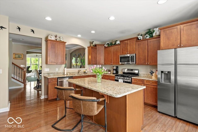 681 Greenford Trl N, Carmel, IN 46032 - kitchen with appliances with stainless steel finishes, arched walkways, a center island, a kitchen breakfast bar, and recessed lighting
