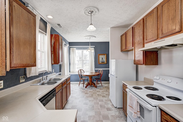 kitchen with pendant lighting, under cabinet range hood, a sink, white appliances, and light countertops