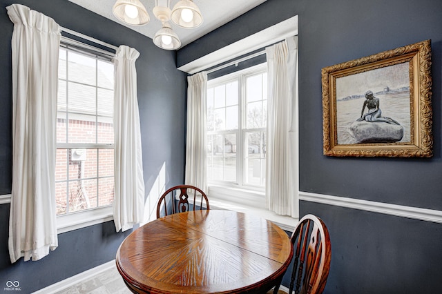 dining area featuring baseboards and a chandelier