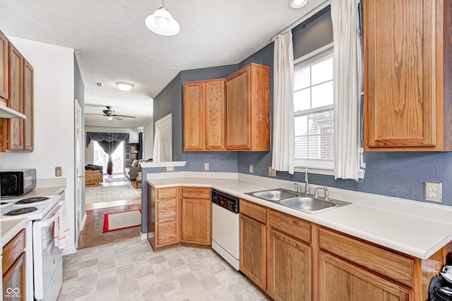 kitchen with a sink, white appliances, open floor plan, and light countertops